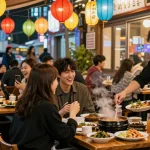 Friends enjoying traditional Korean nightlife at 상봉동 한국관나이트, vibrant atmosphere with colorful lanterns.